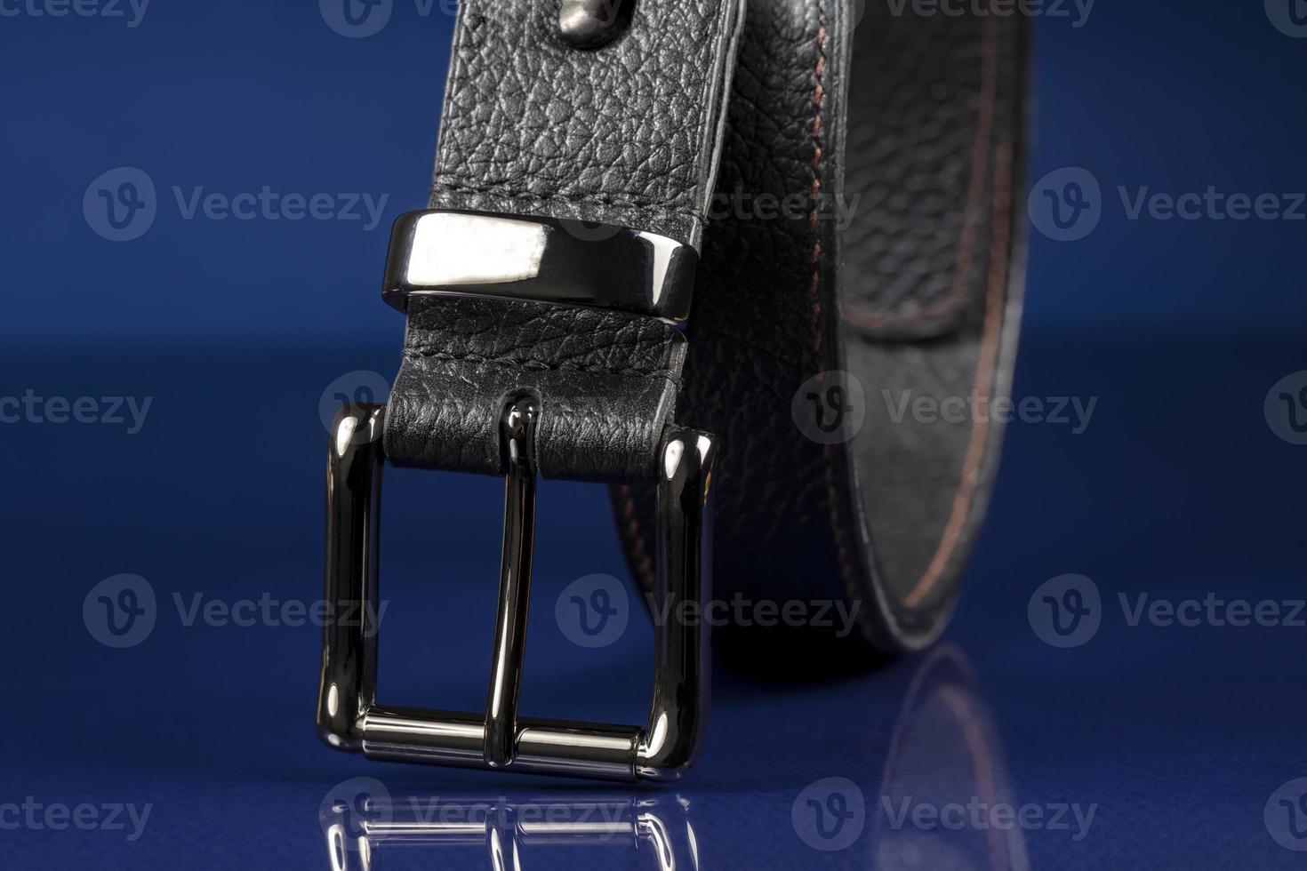 cinturón de cuero negro sobre un fondo azul oscuro. foto