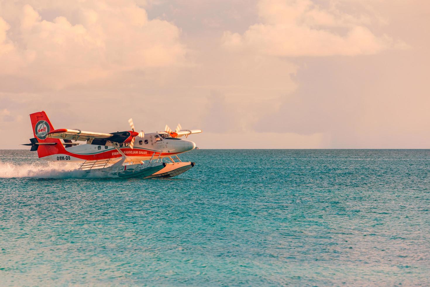 06.01.2019 - Ari Atoll, Maldives Exotic scene with seaplane on Maldives sea landing. Vacation or holiday in Maldives concept background. Cool sunset photo. Exotic transportation, airline as seaplane photo