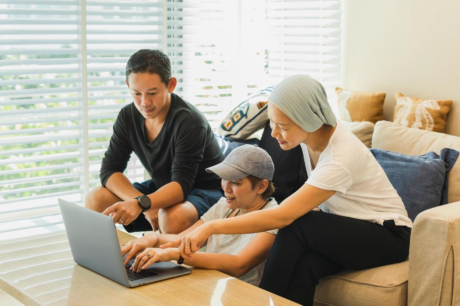 tres colegas que trabajan en una computadora portátil en casa. foto