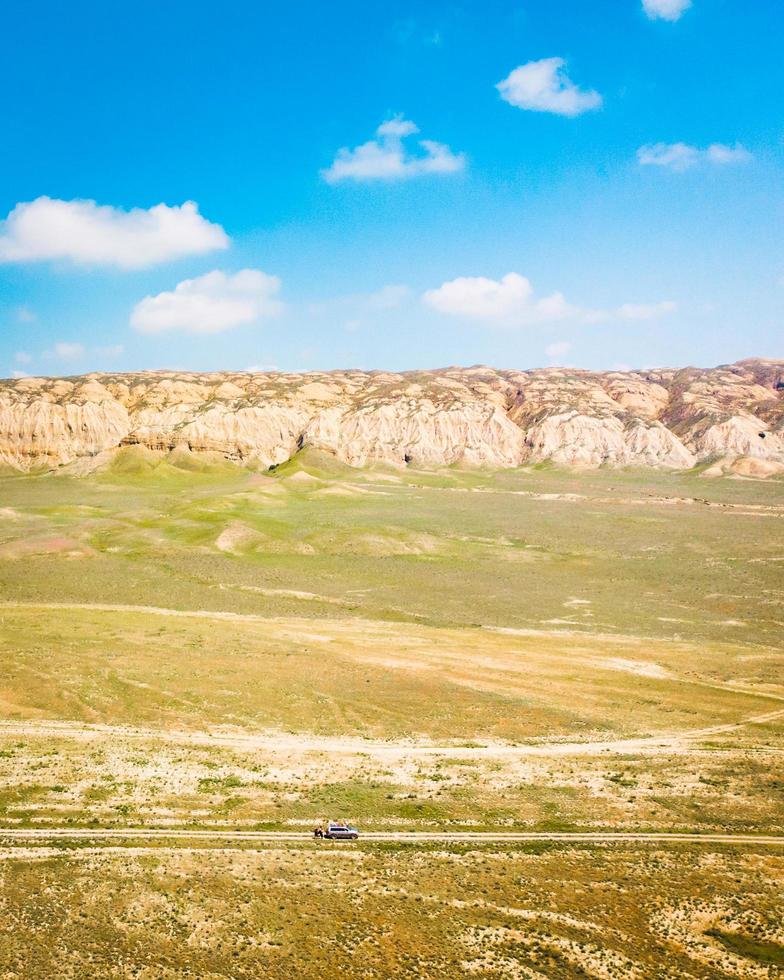 vista aérea del pintoresco paisaje georgiano con camión 4wd parado en el valle del río seco. parque nacional vashlovani foto