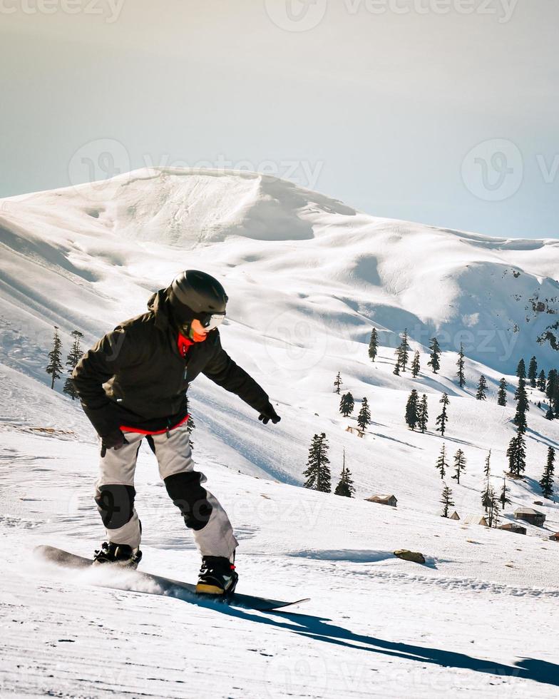 Close up snowboarder snowboard fast on slope downhill in winter ski resort. Sports wear, fun in Goderdzi ski resort in Georgia. Caucasus winter holidays. photo