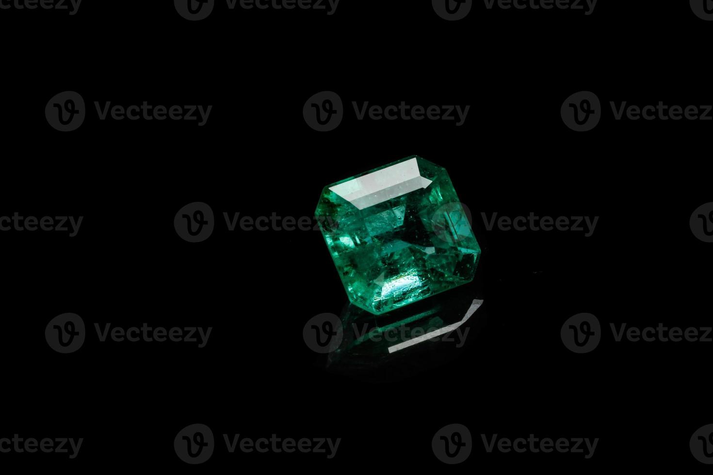 Macro mineral Emerald gemstone faceted on black background photo