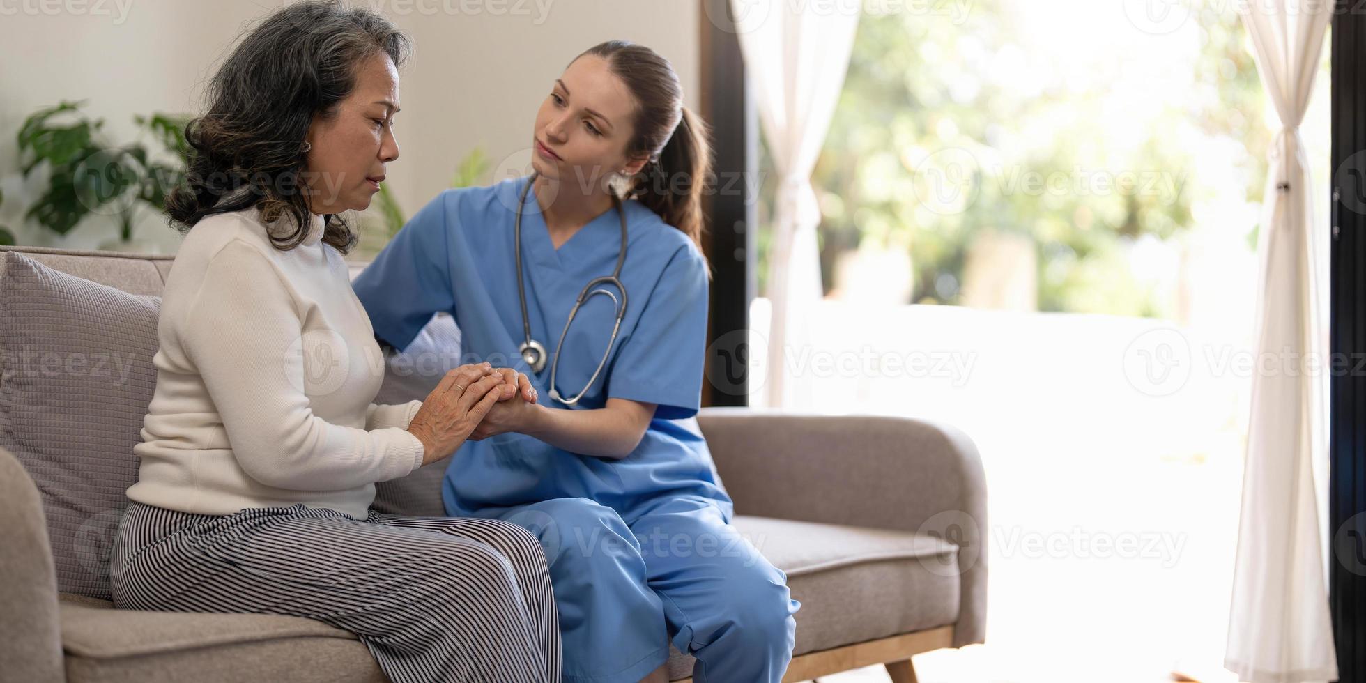 el paciente feliz sostiene al cuidador por una mano mientras pasan tiempo juntos. anciana en hogar de ancianos y enfermera. foto