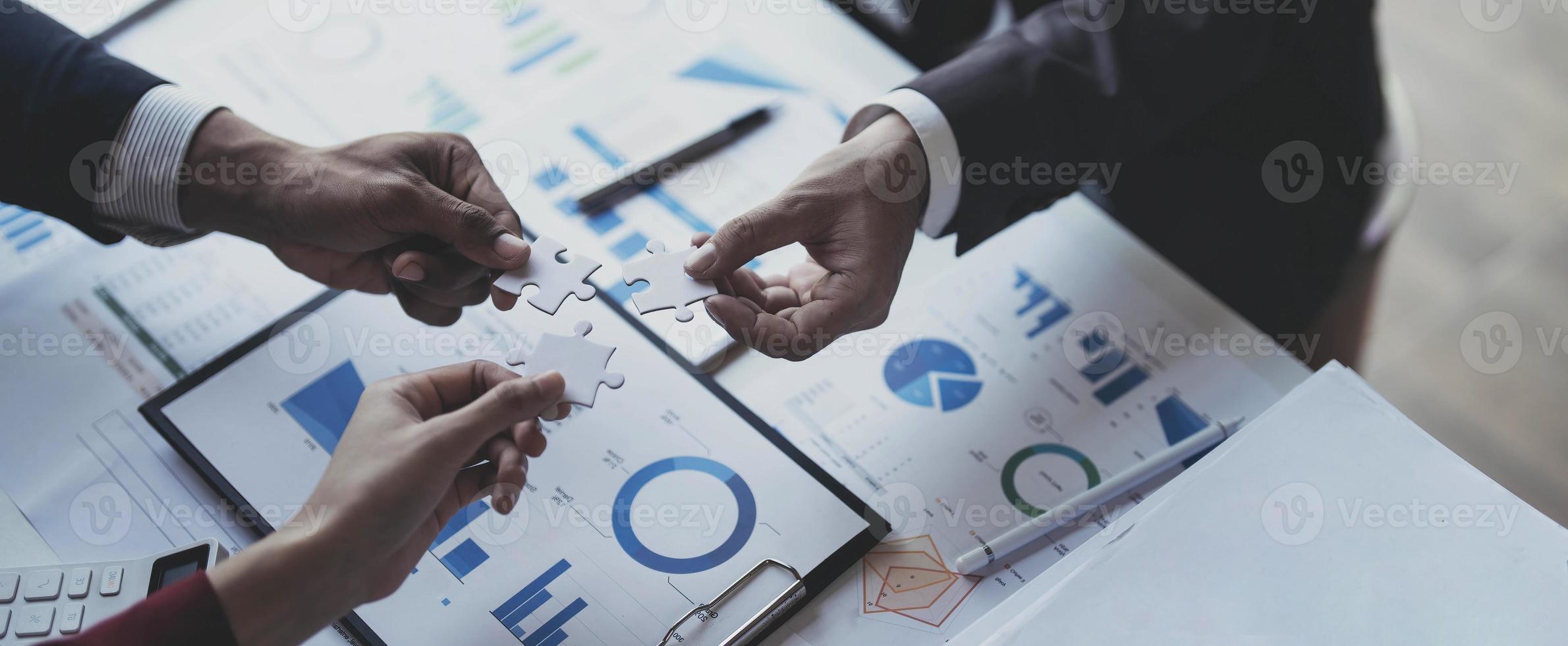 A group of business people assembling jigsaw puzzle. The concept of cooperation, teamwork, help and support in business. photo