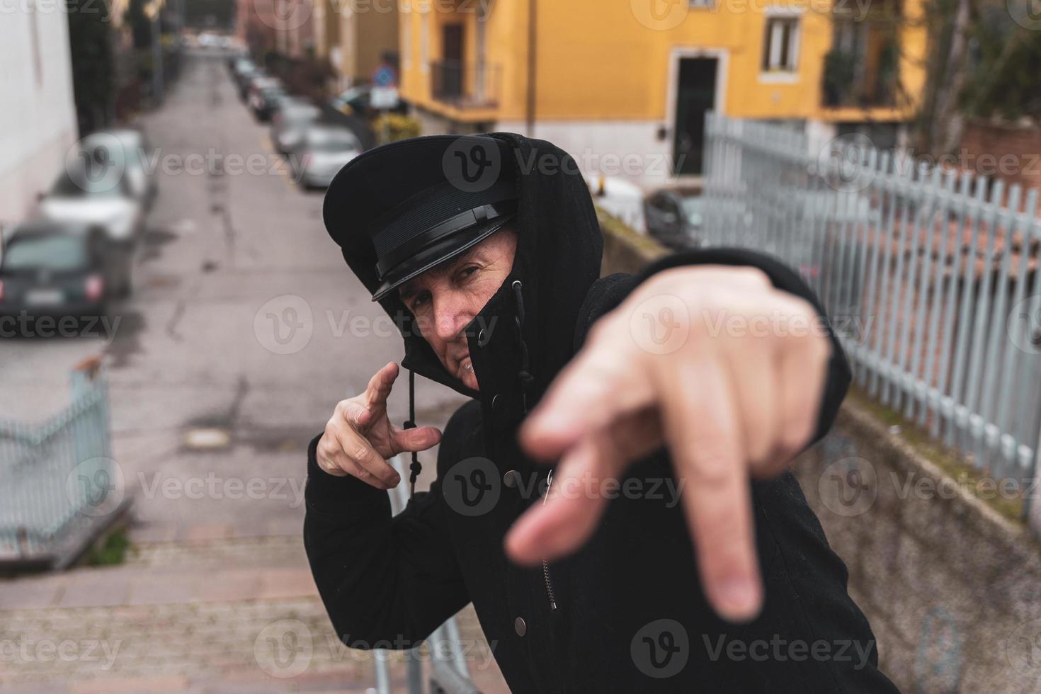 mature man rap singer posing in the street on the outskirts of a city photo