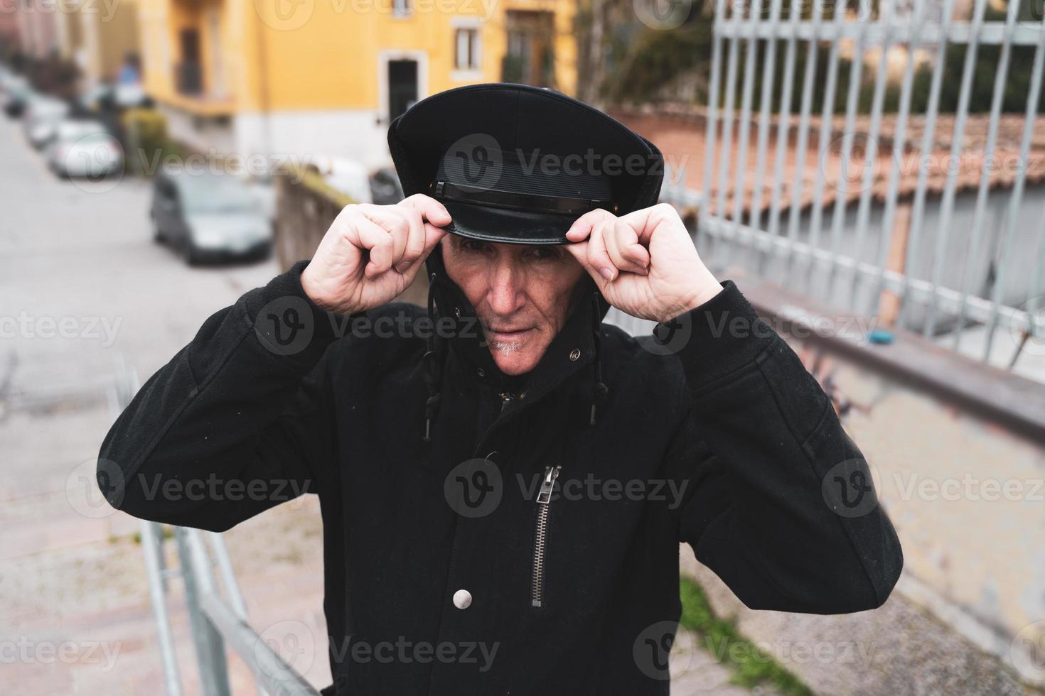 mature man rap singer posing in the street on the outskirts of a city photo