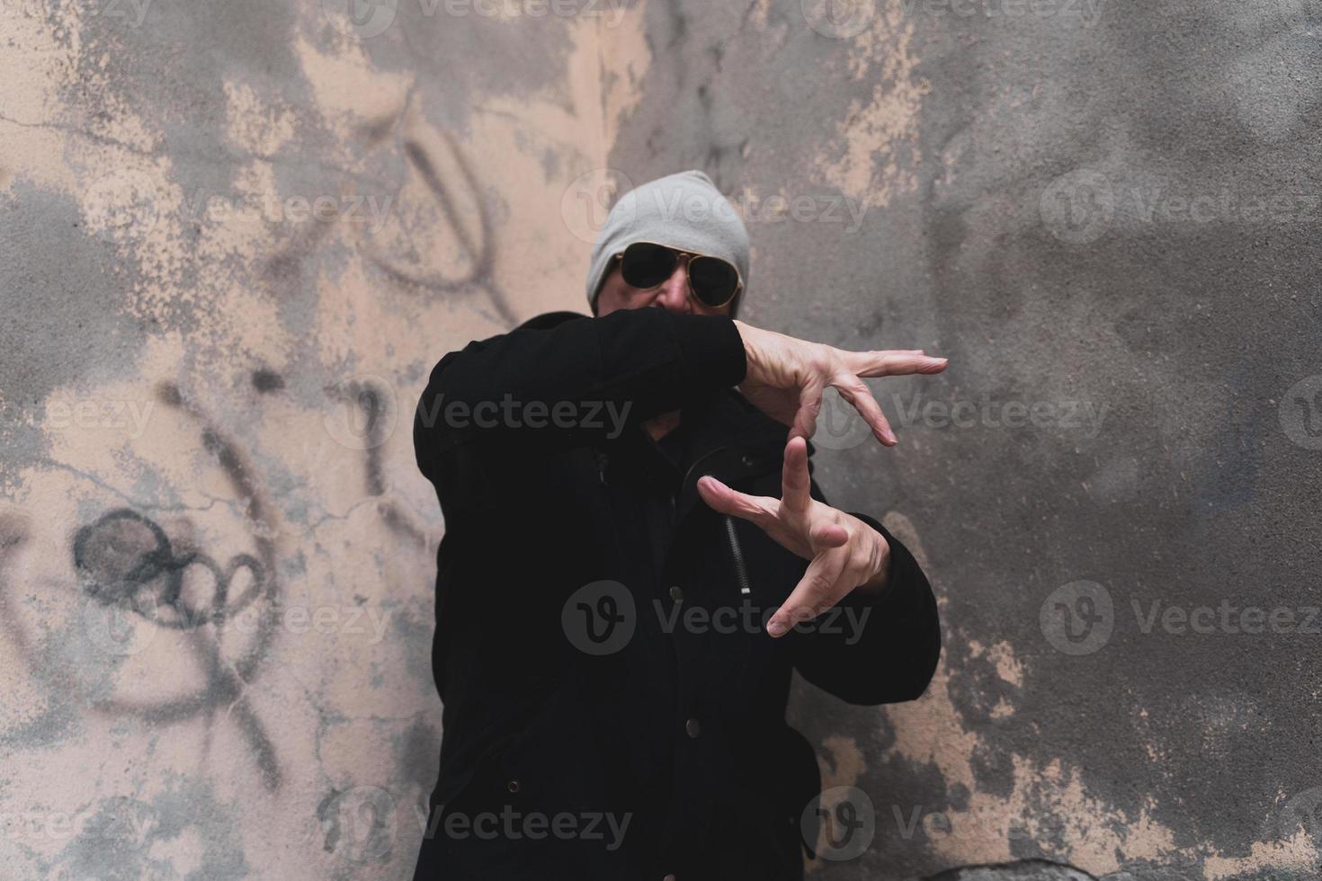 mature man rap singer posing in the street on the outskirts of a city photo