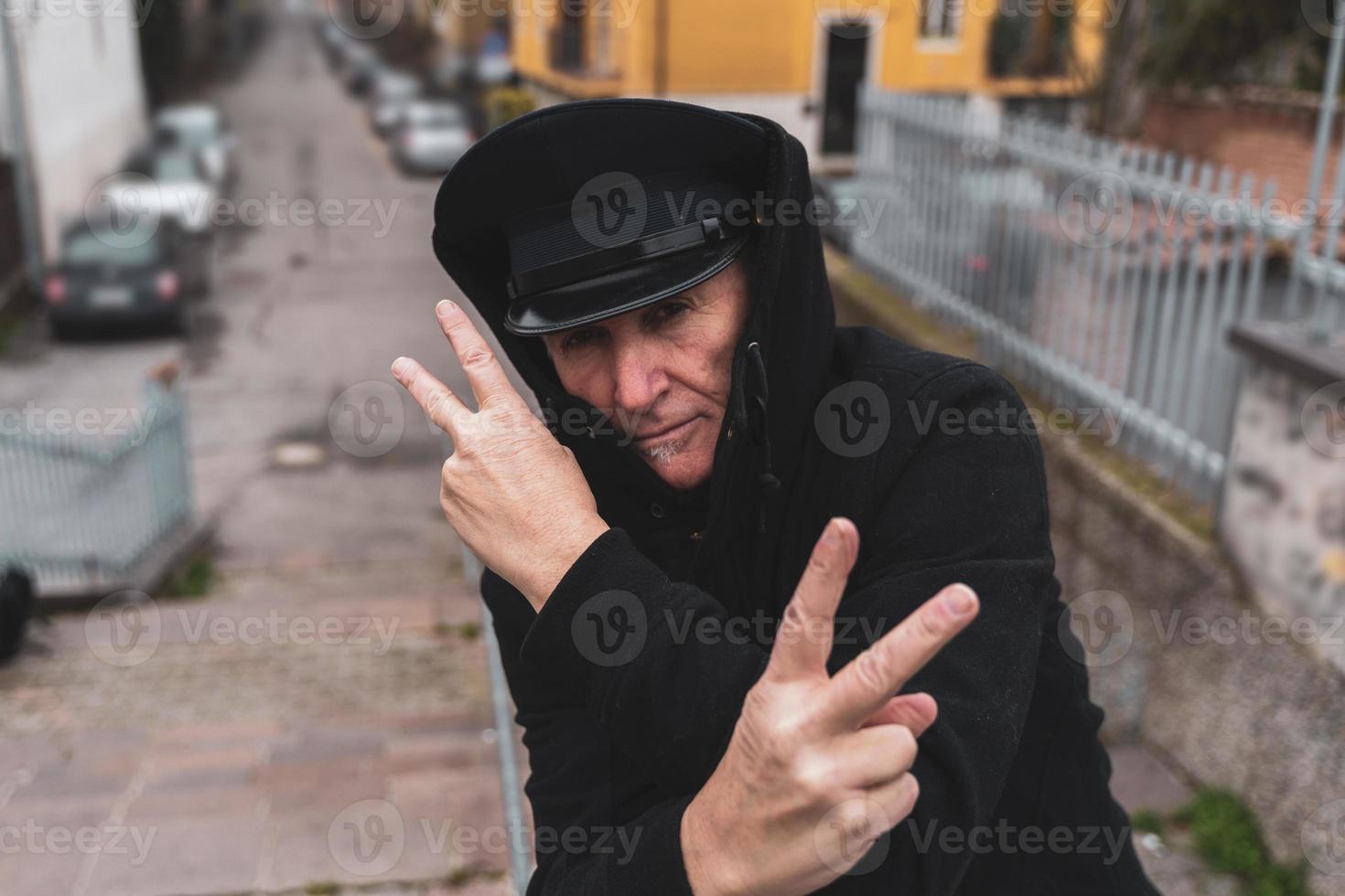 mature man rap singer posing in the street on the outskirts of a city photo