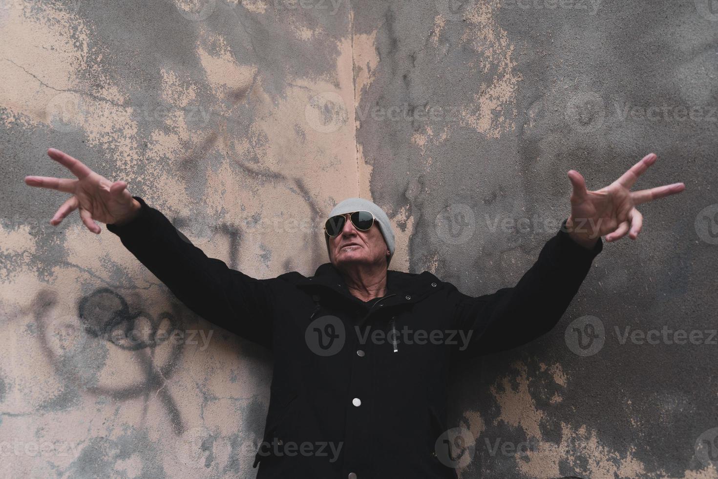 Cantante de rap de hombre maduro posando en la calle en las afueras de una ciudad foto