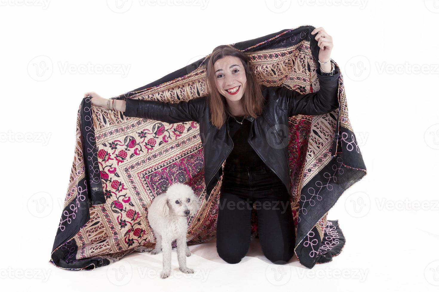 pretty girl plays with her dog under a blanket on white background photo