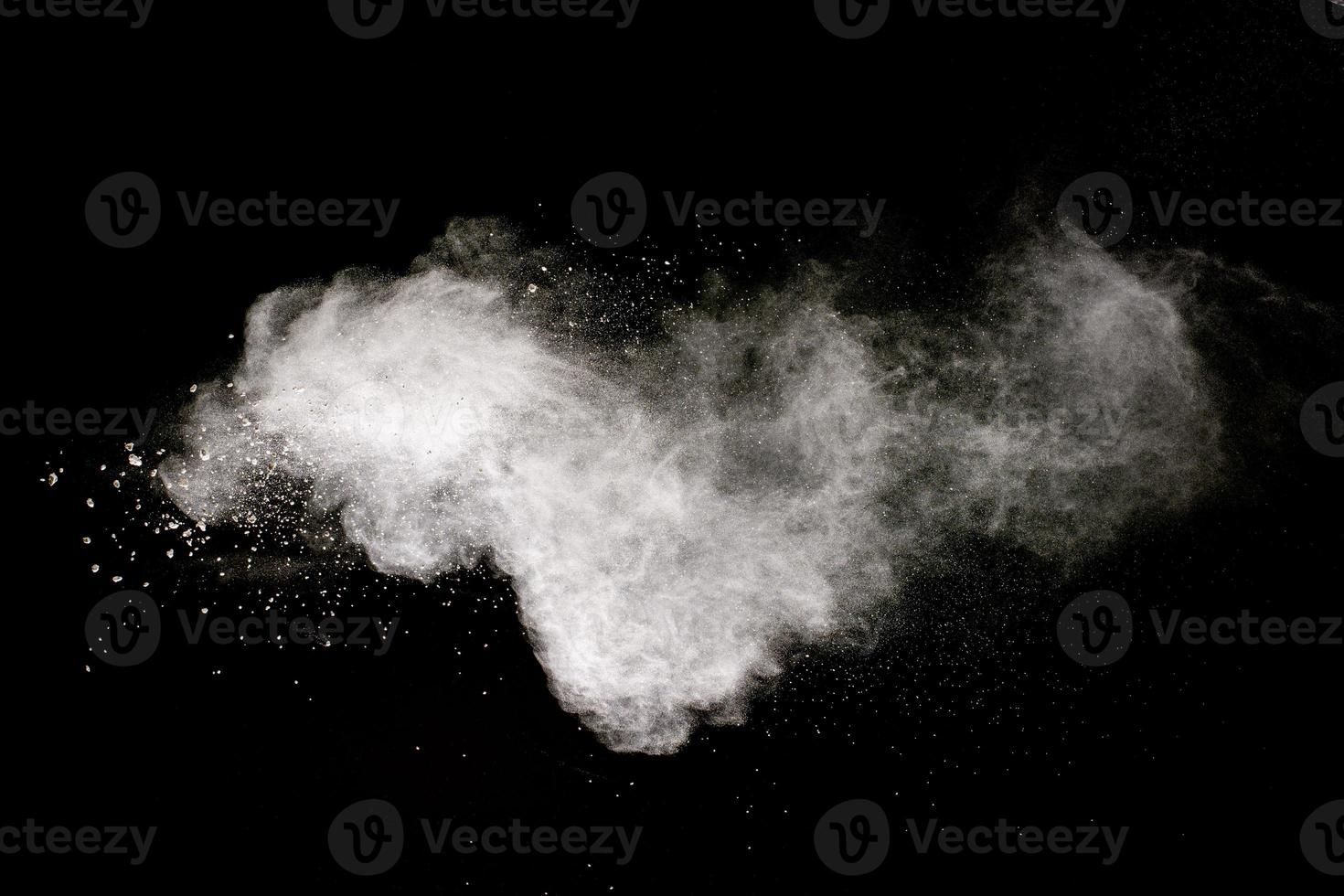 White powder explosion cloud against black background.White dust particle splash. photo