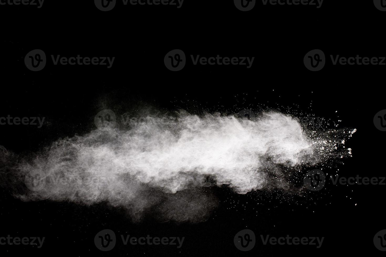 White powder explosion cloud against black background.White dust particle splash. photo