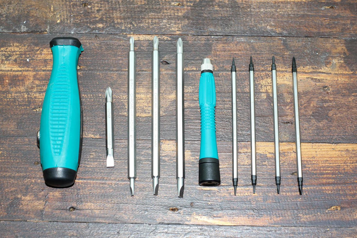 Tool set screwdriver with replaceable bits, on the wooden background photo