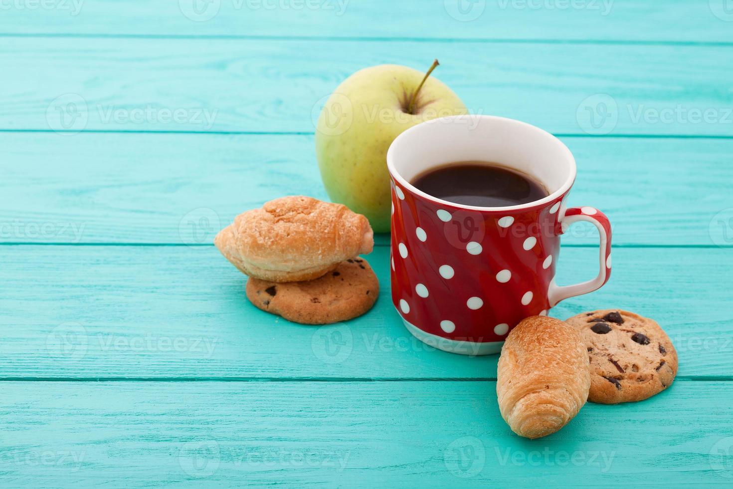 Cup of coffee with croissants on blue wooden table. Selective focus photo