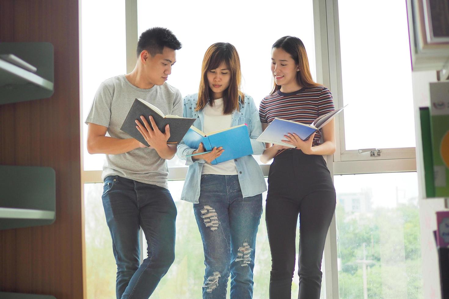 A group of students preparing to take the exam are reading books together in the library. photo