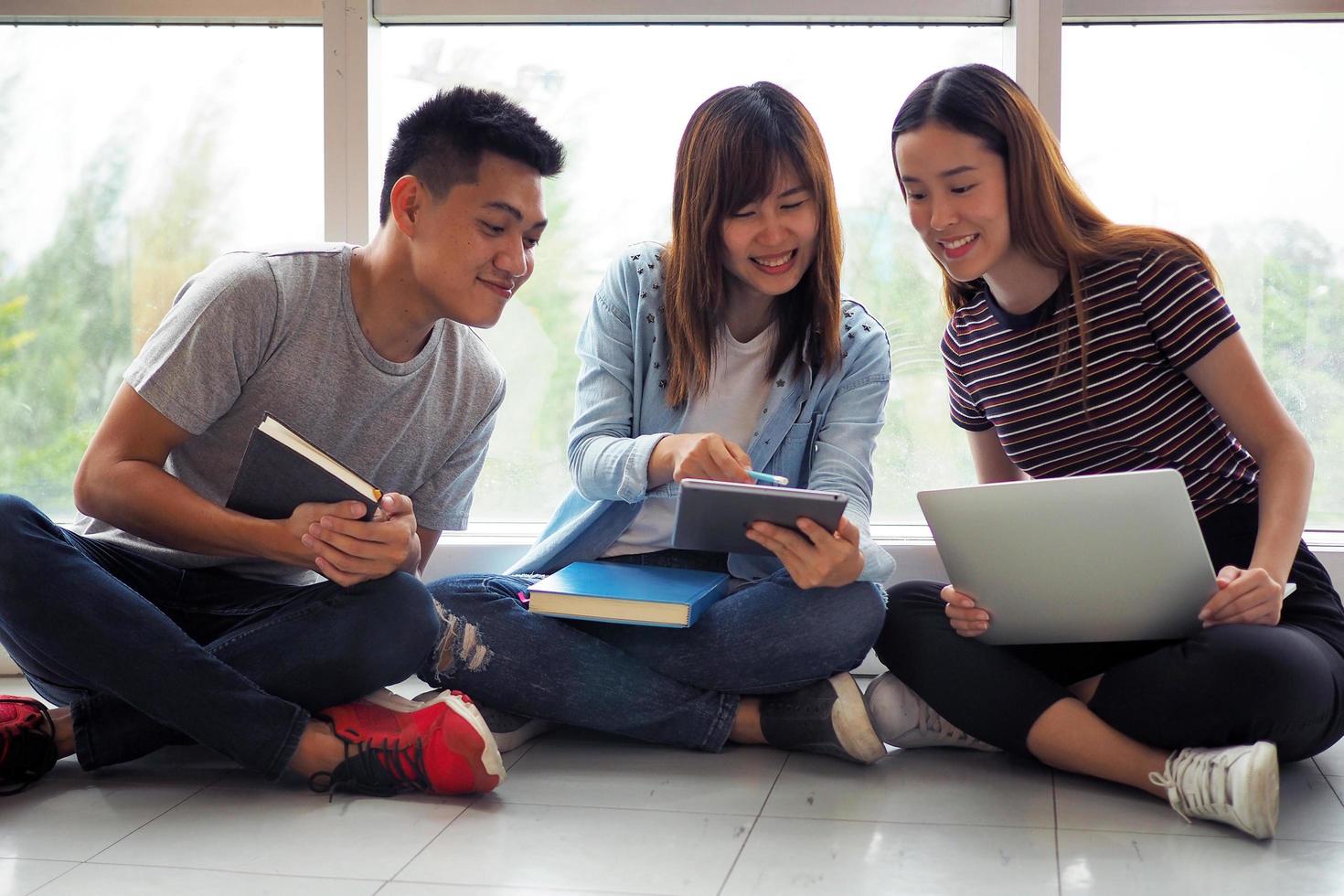 Student groups are viewing information in the tablet. Having a gesture of agreement and smiling, happy to study together. photo