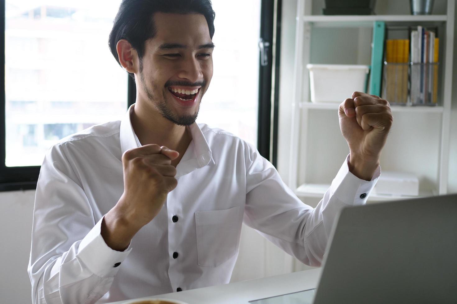 el gerente se veía alegre mientras miraba la computadora. concepto de ganador foto