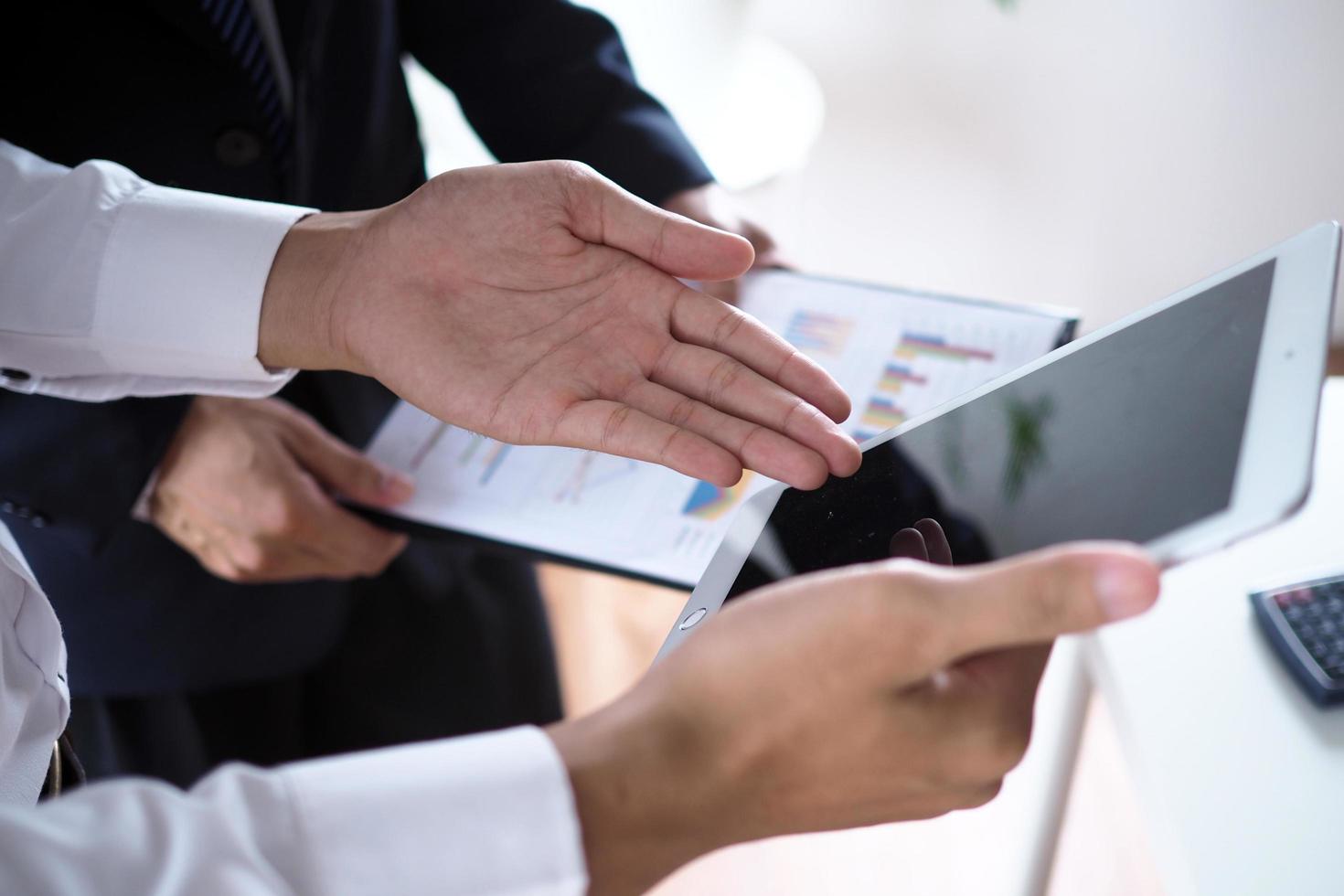 Businessmen are using tablets to view business information together. photo