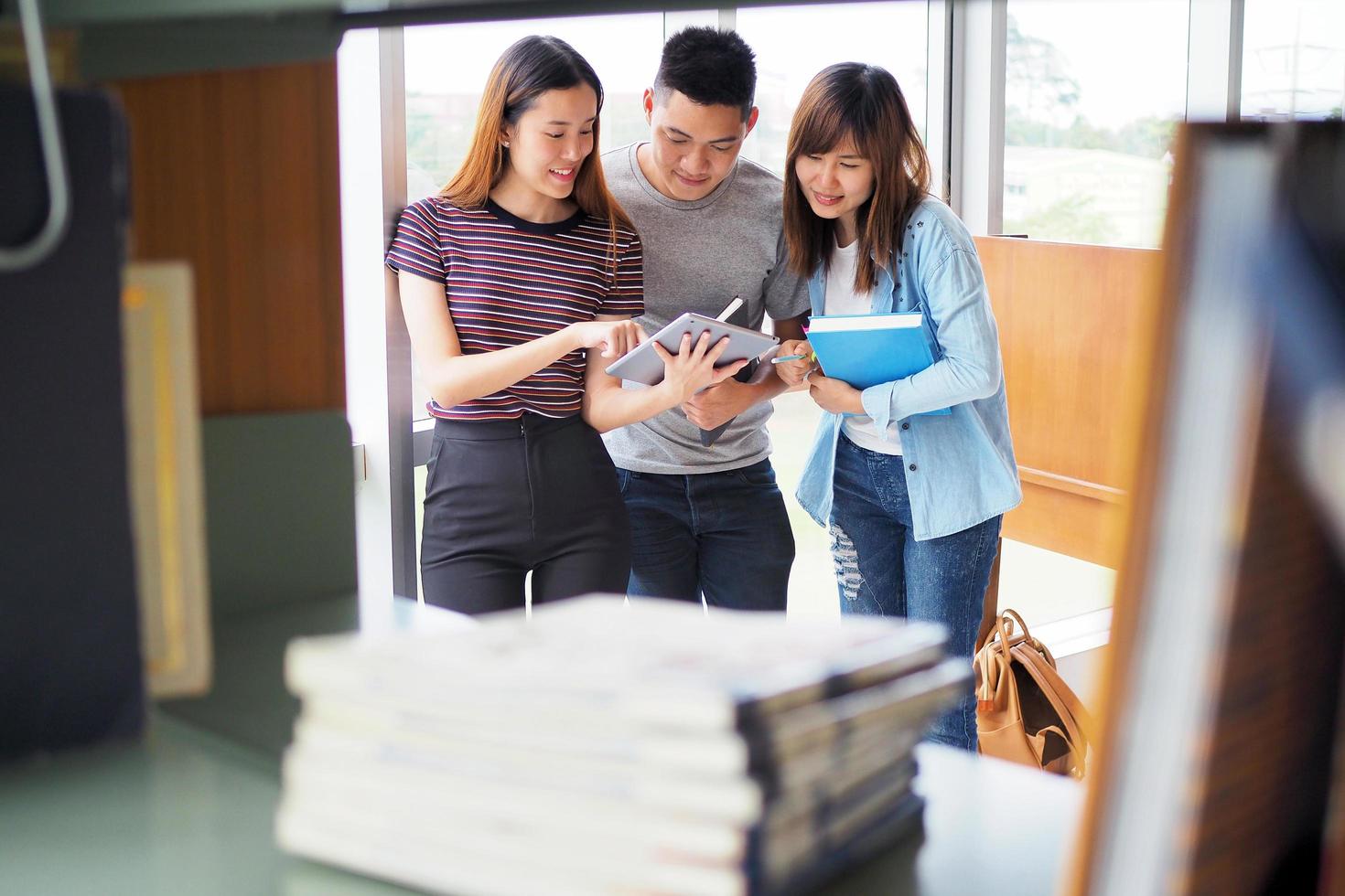 Student groups are viewing information in the tablet. Having a gesture of agreement and smiling, happy to study together. photo