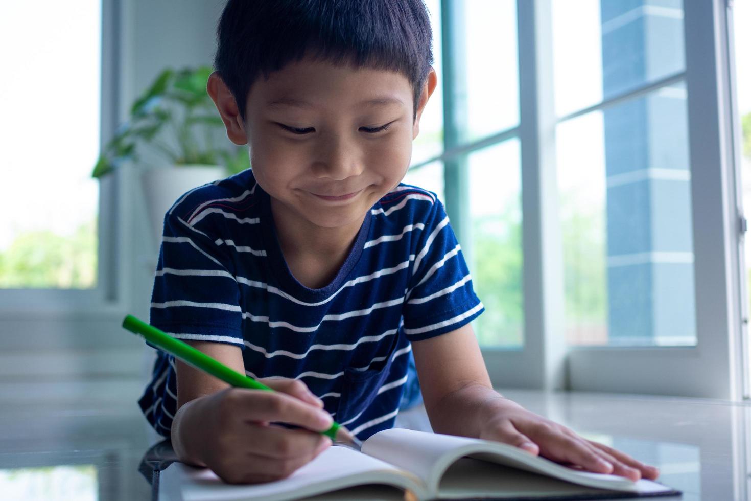 The little boy is reading a book in the house area. Learning at home photo