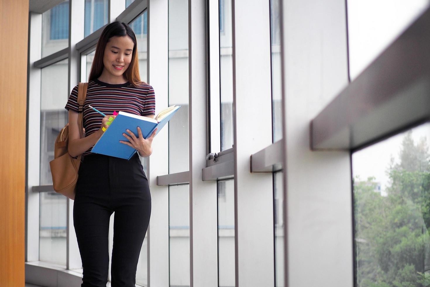 Asian students stand reading books in the university library. photo