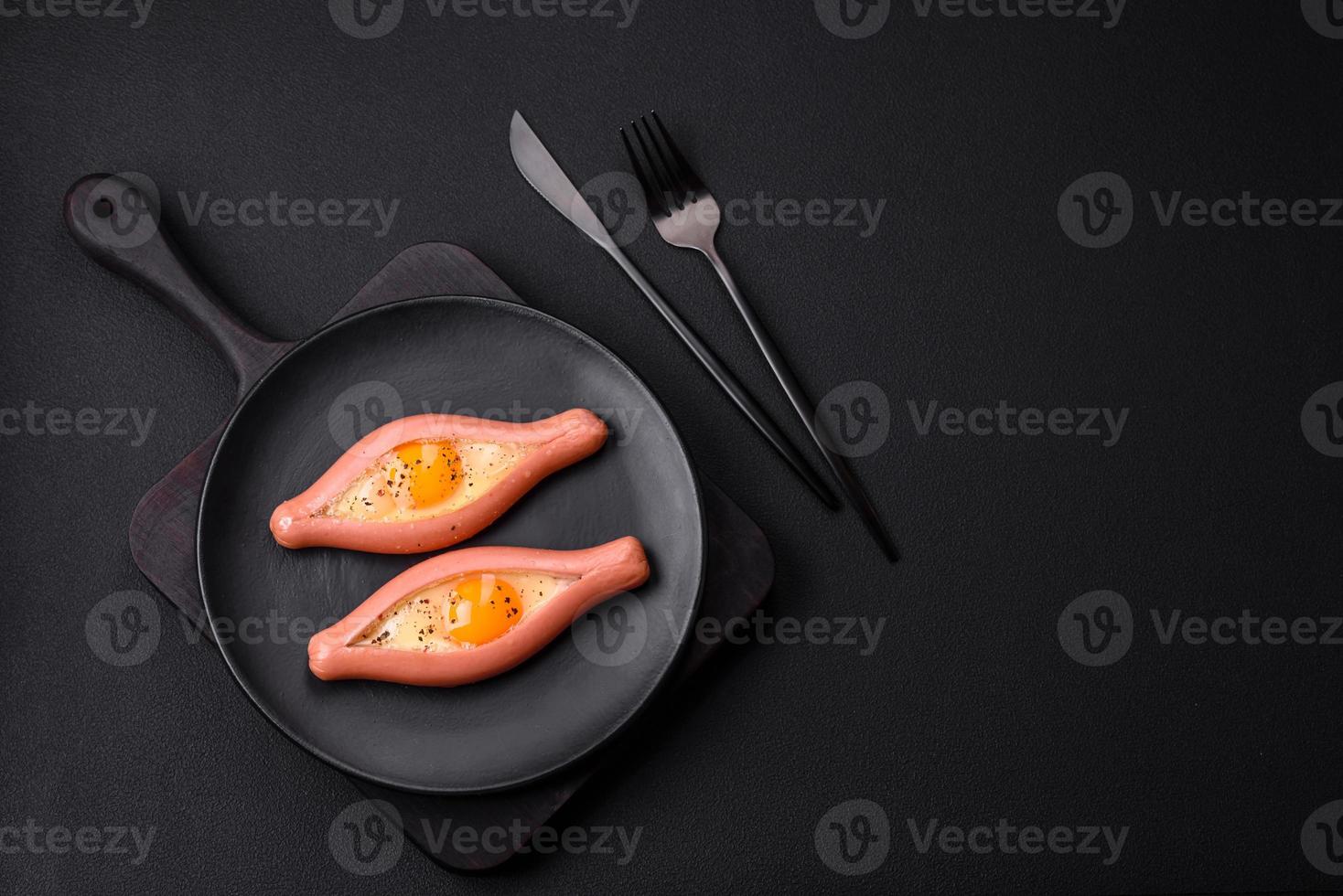 Composite concept of fried eggs inside a cut sausage with spices photo