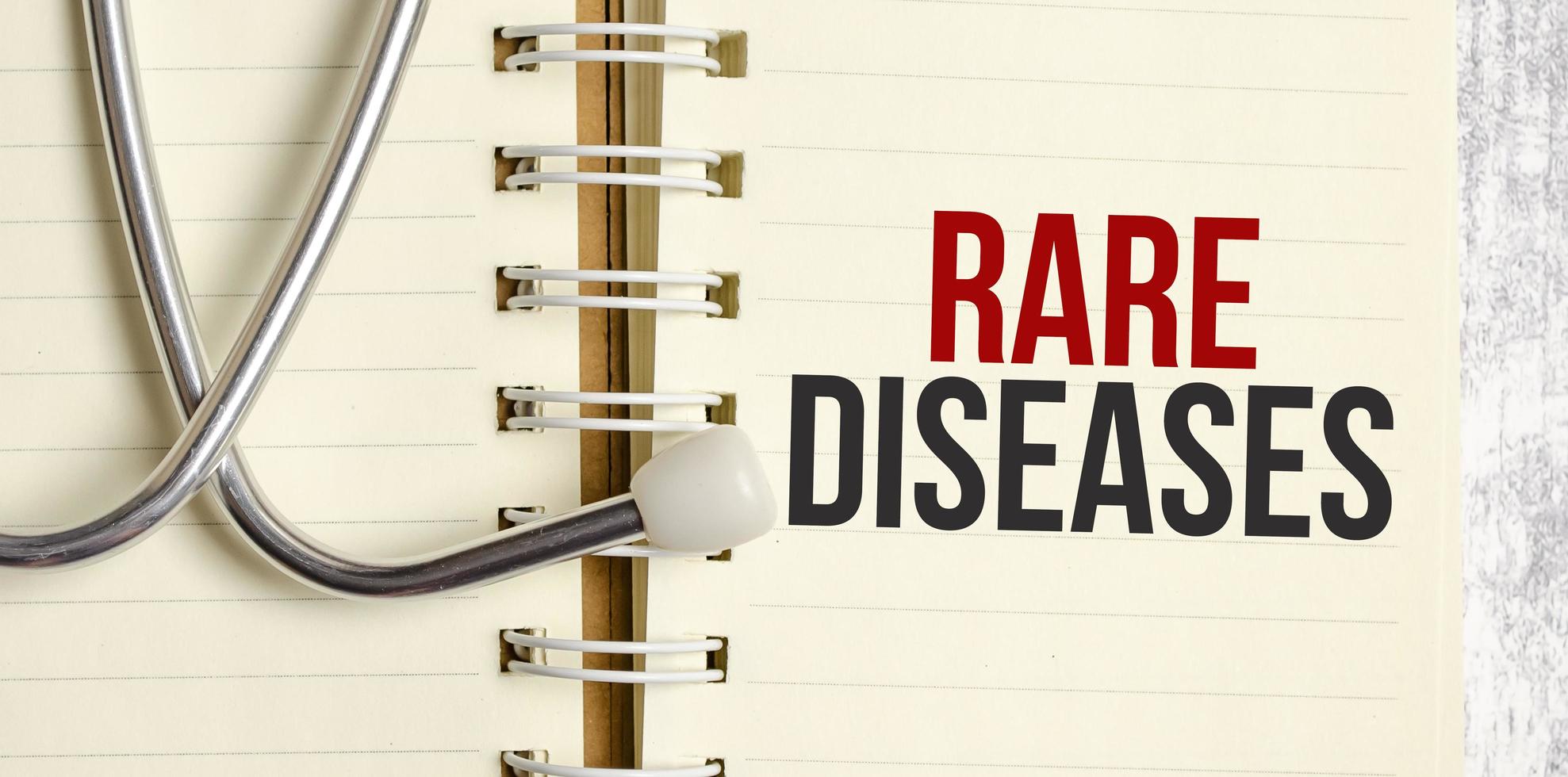 estetoscopio y cuaderno con texto de enfermedades raras en el cuaderno foto