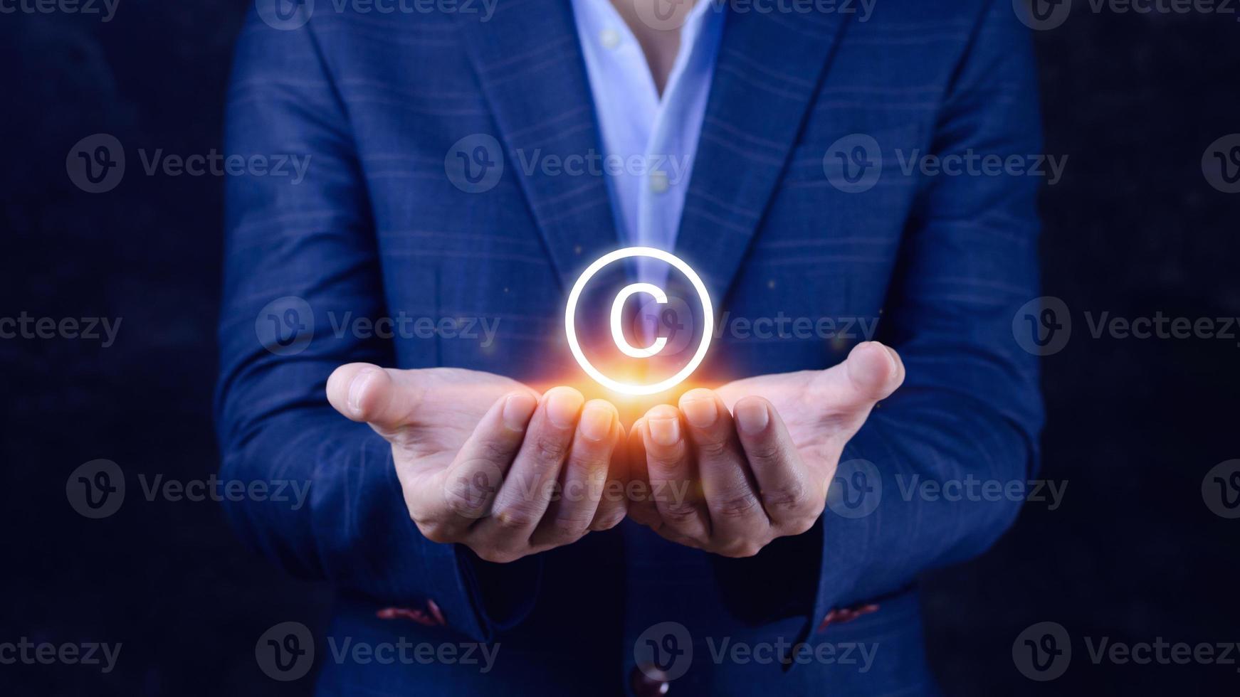 Businessman holding Copyright icon, patents and intellectual property protection law and rights. with symbol of the copyright.copyright symbol from the author. photo
