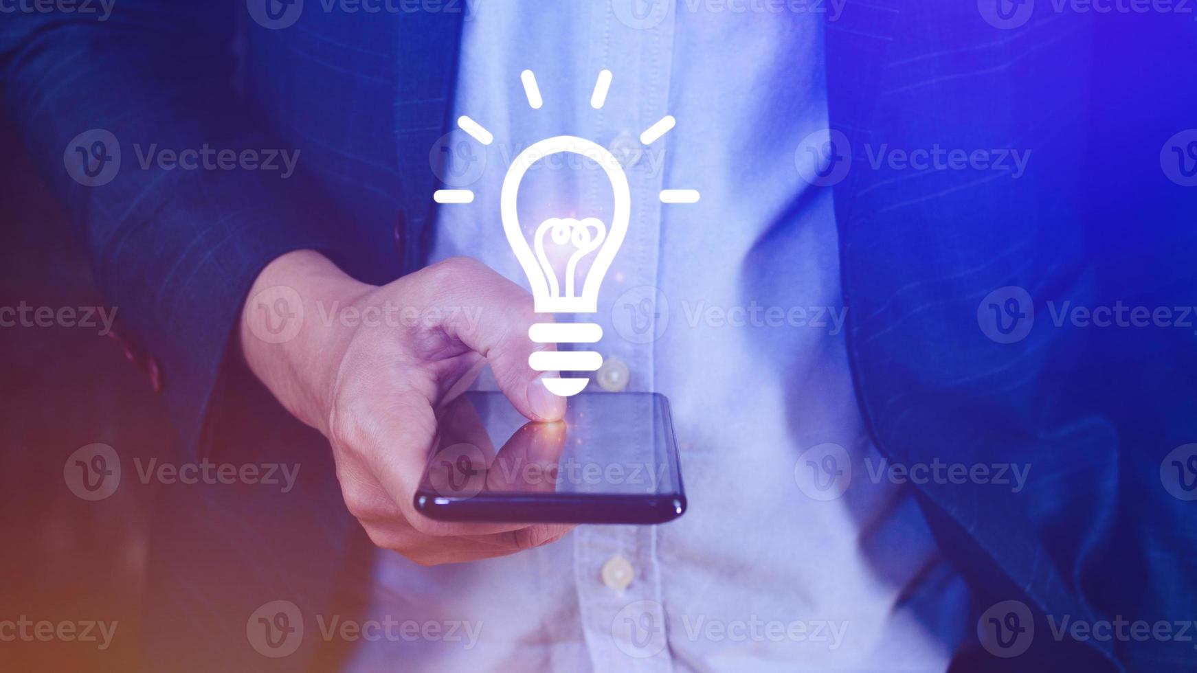 Hands holding smartphone with light bulb Bright idea, light bulb for concept new idea concept with innovation and inspiration, technology in science and communication concept photo