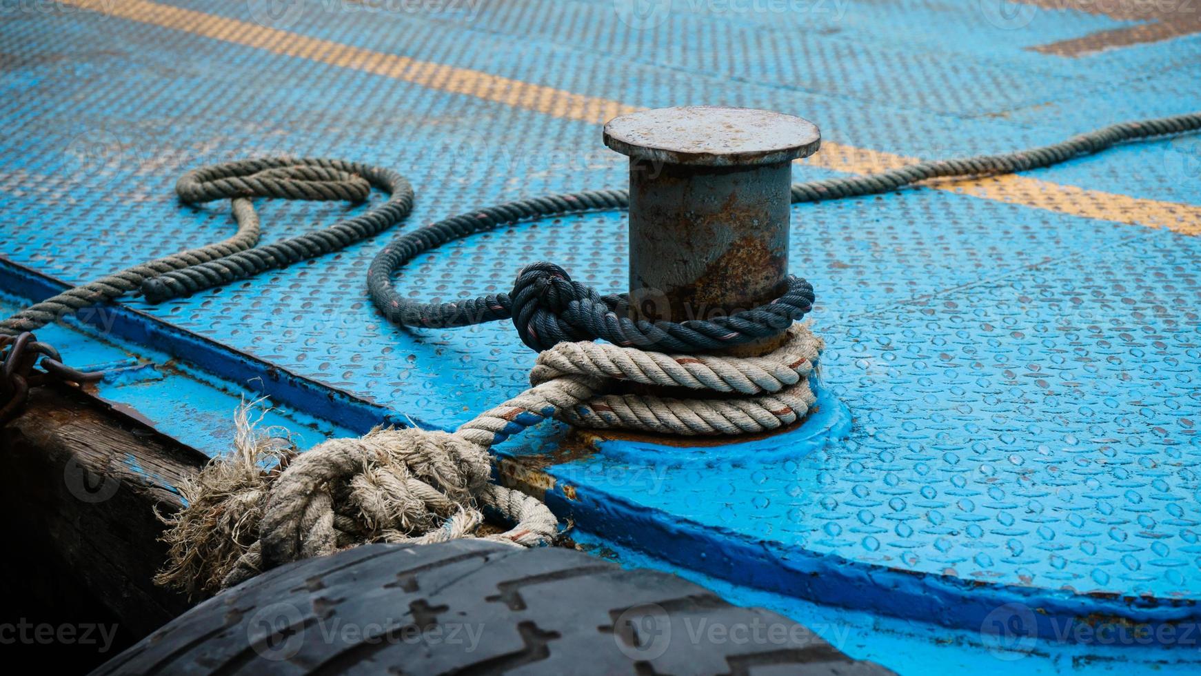 Boat rope tied up on a bitt Large steel bollard at the harbour photo