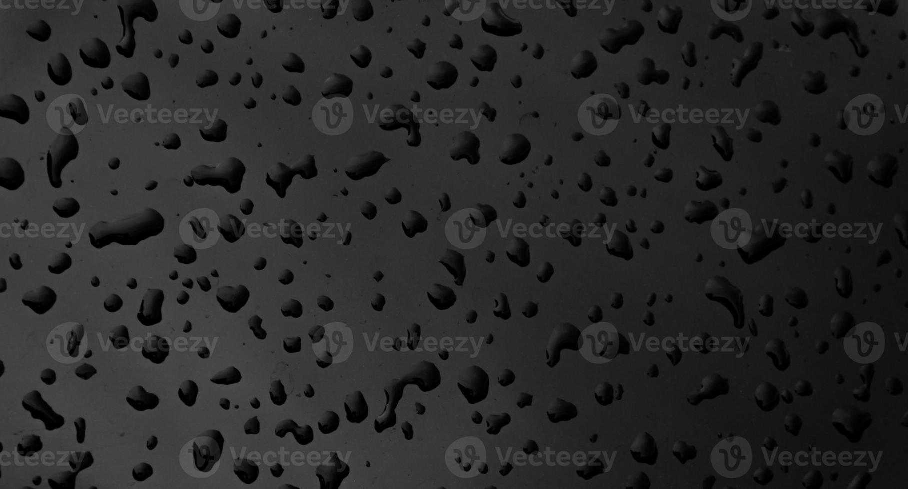 Water drops on black dark surface  texture background photo