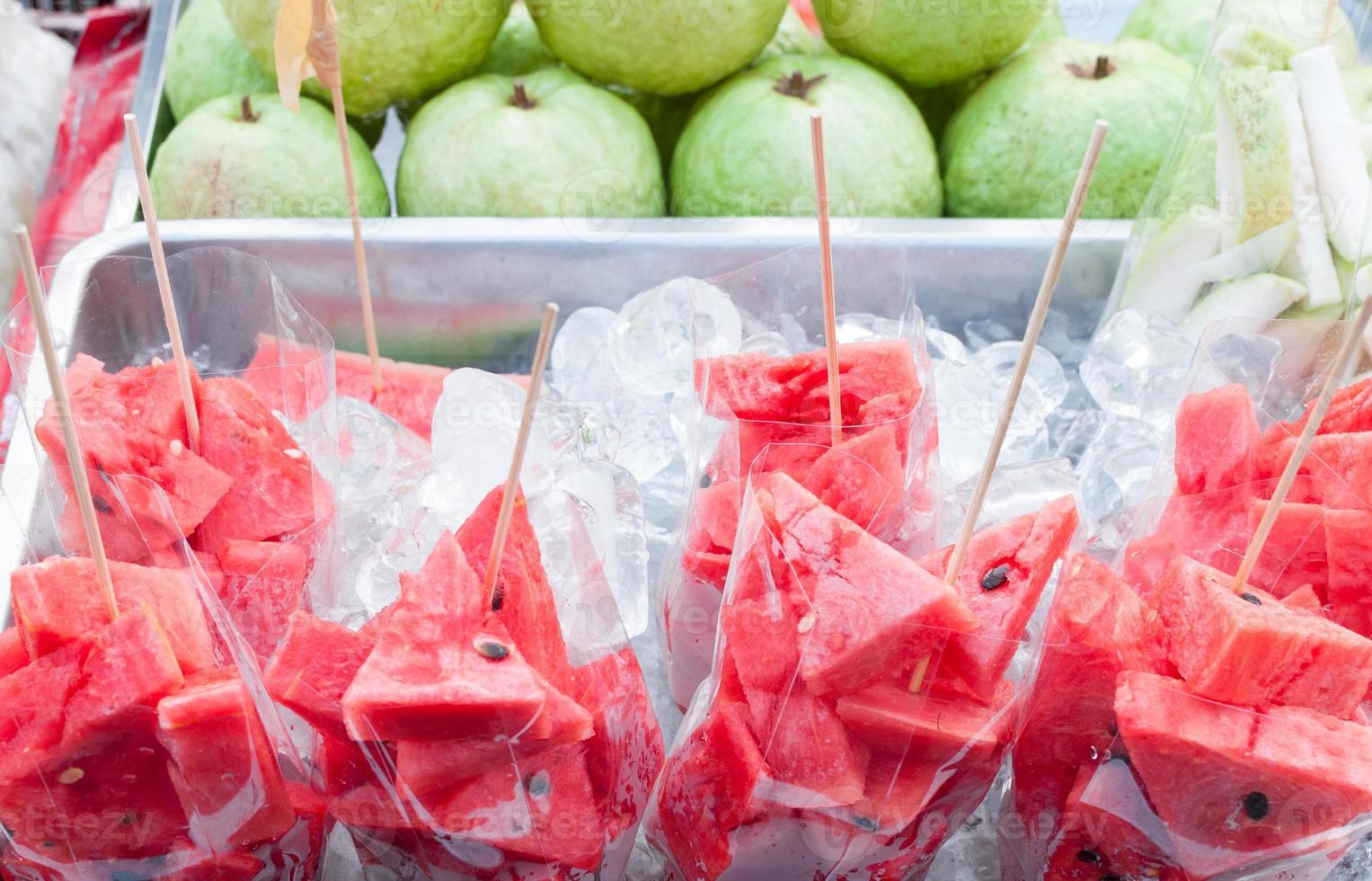 sandía roja fresca en rodajas en una caja de hielo en el mercado de tailandia, bocadillos naturales saludables, fruta lista para comer foto