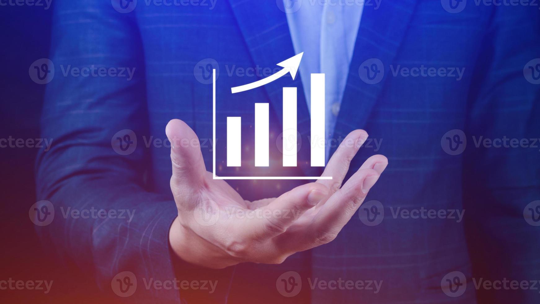 Businessman showing business growth on graph Hands touching graphs representing increasing profits with virtual interface technology, financial symbols coming photo