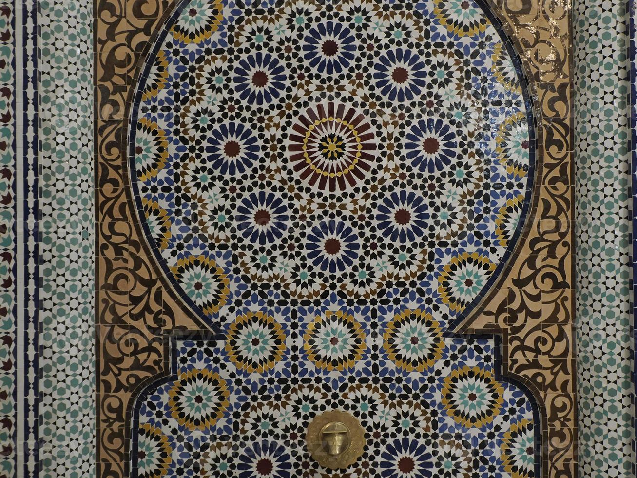 Mosaico marroquí artesano pintando y decorando productos cerámicos en la fábrica de cerámica en Fez, Marruecos foto