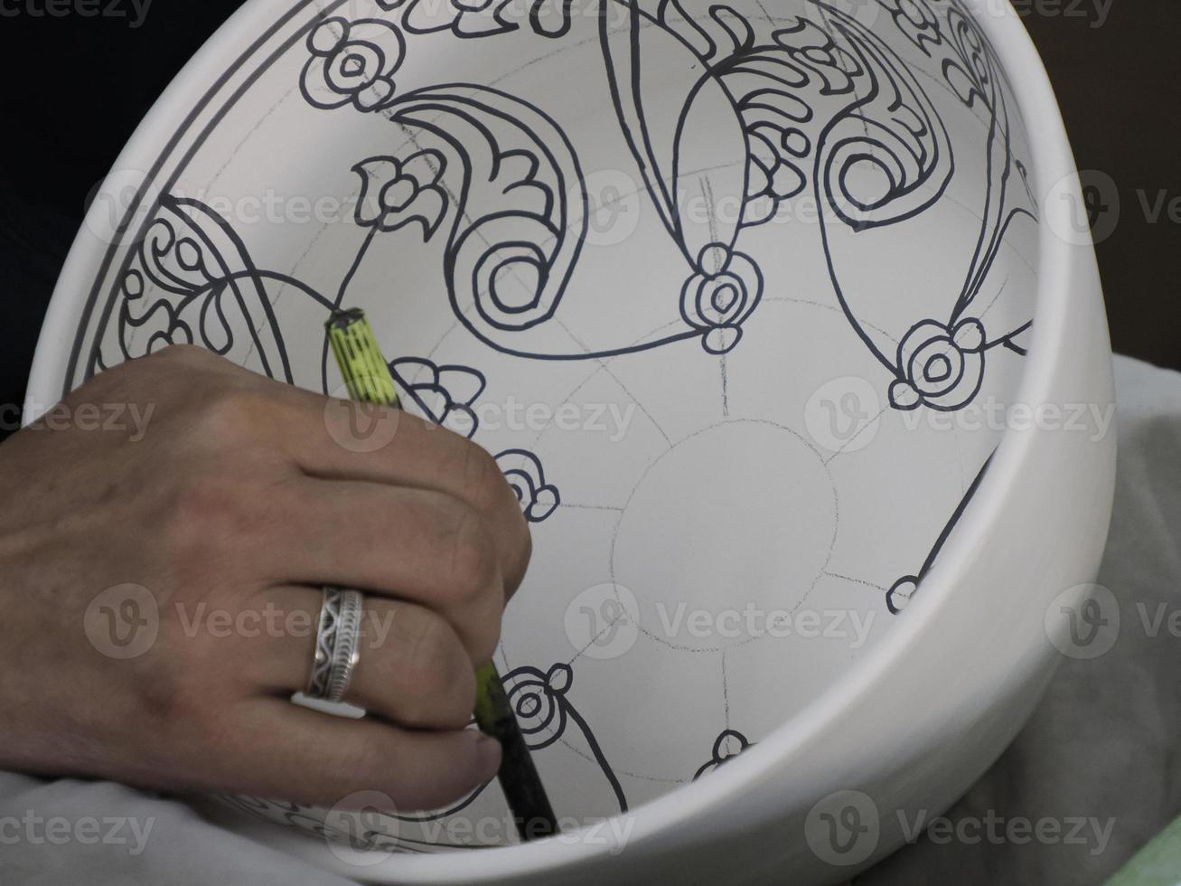 Moroccan Craftsman painting and decorating ceramic products in pottery factory in Fez, Morocco photo