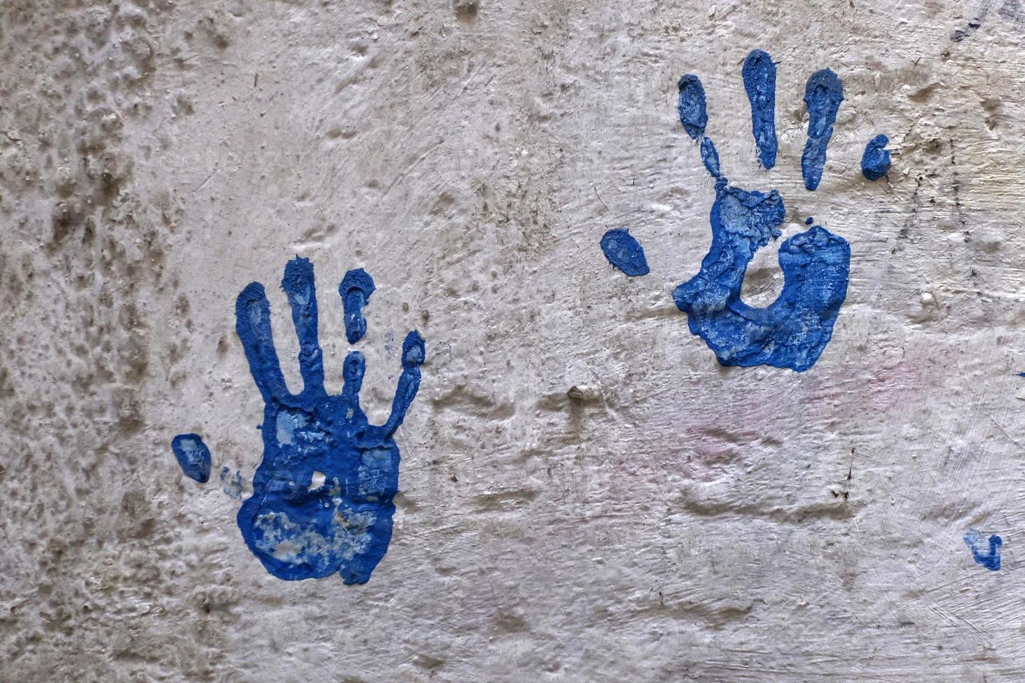 impresión de mano de color azul en la pared blanca foto