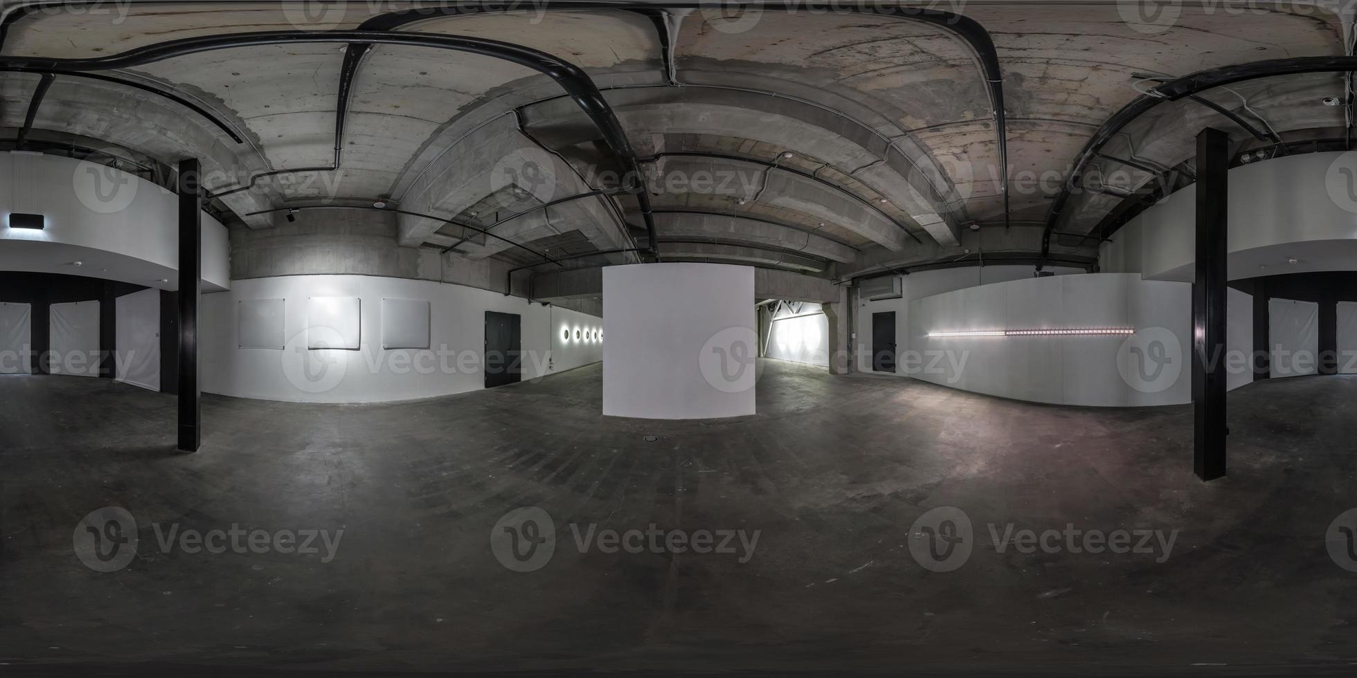 panorama hdri 360 esférico sin costuras en el interior oscuro de una gran habitación vacía como almacén, hangar o galería con focos en proyección equirectangular. concepto de realidad virtual foto