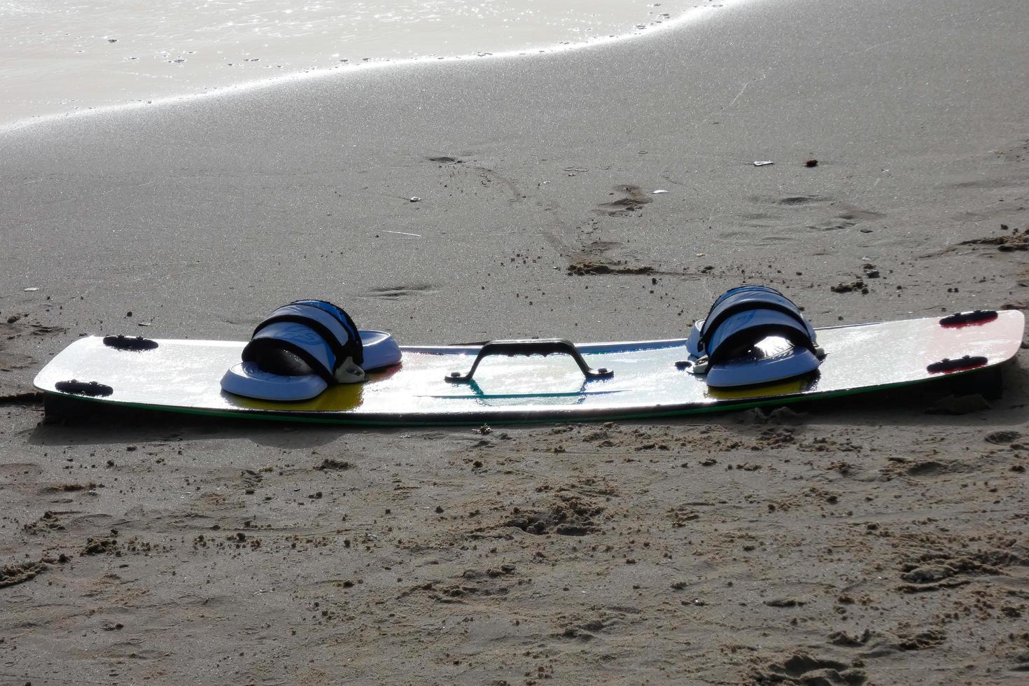 snowboard en la arena mojada de una playa para disfrutar de deportes acuáticos foto