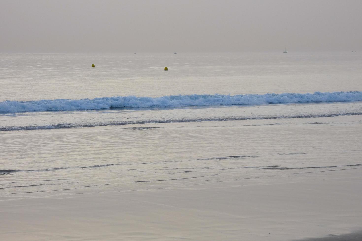 lonely, uncrowded beach with calm sea and small waves photo