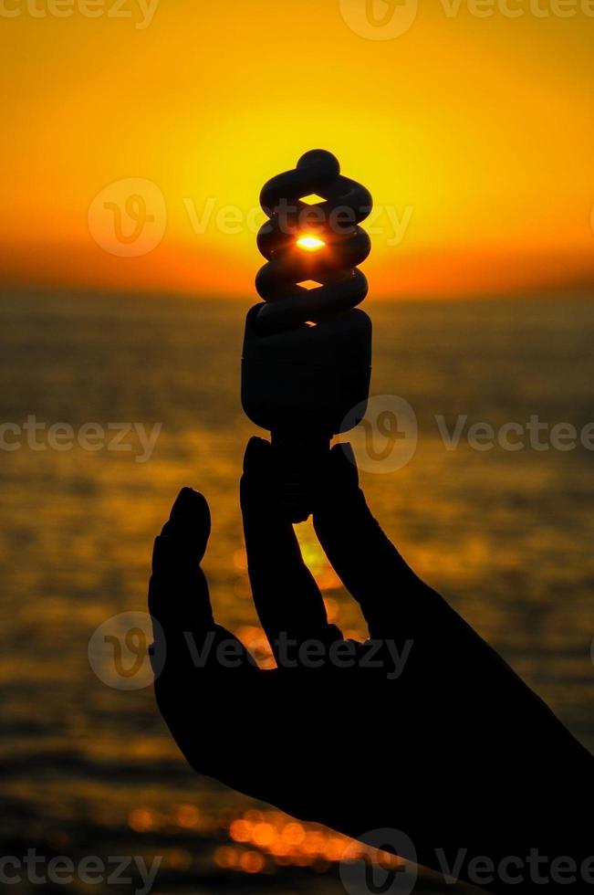 Energy Concept with lamp over the sunset photo