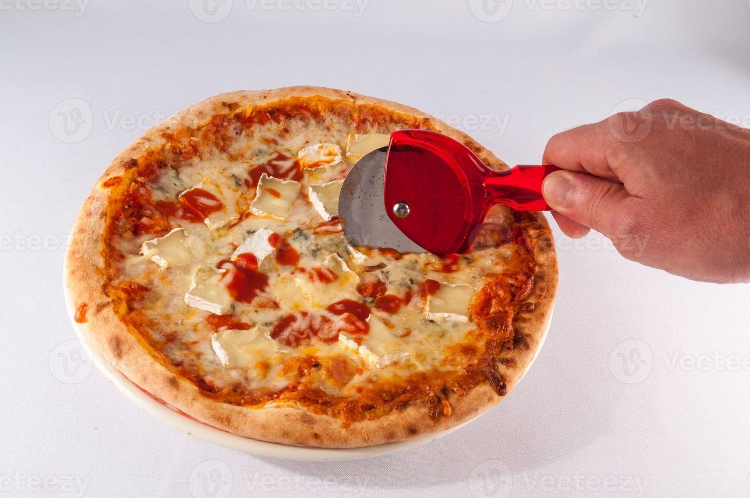 Hand cutting a pizza photo