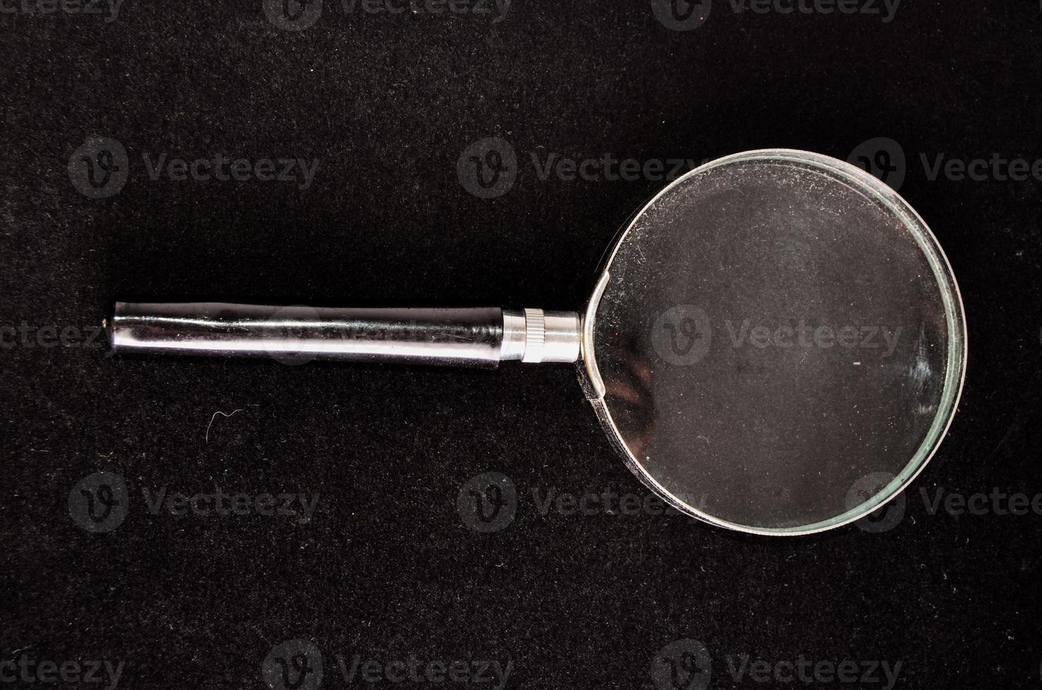 Magnifying glass on black background photo