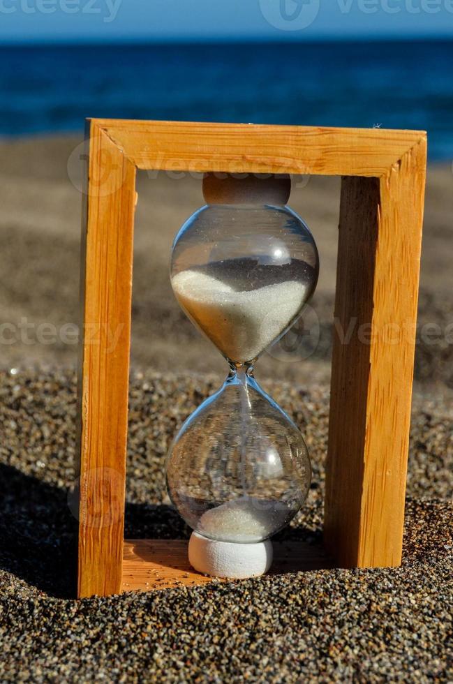 Hourglass on the sand beach photo
