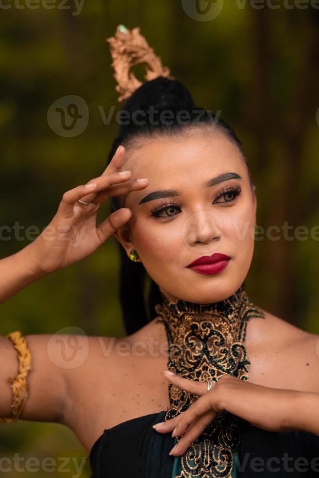 Portrait of an Asian woman in makeup and red lips while wearing a golden necklace and golden accessories on her black hair while standing photo
