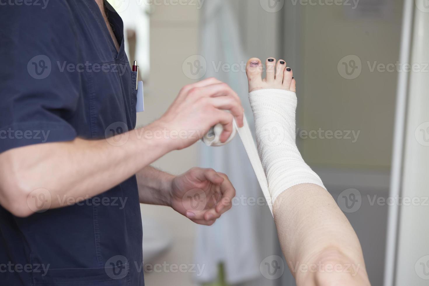 The doctor bandages the patient's leg. Surgeon and patient after vein surgery. photo