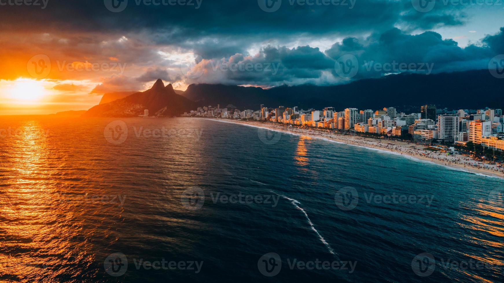 Aerial drone view of Ipanema Beach in Rio de Janeiro, Brazil at sunset with the iconic Two Brother mountains in the background photo