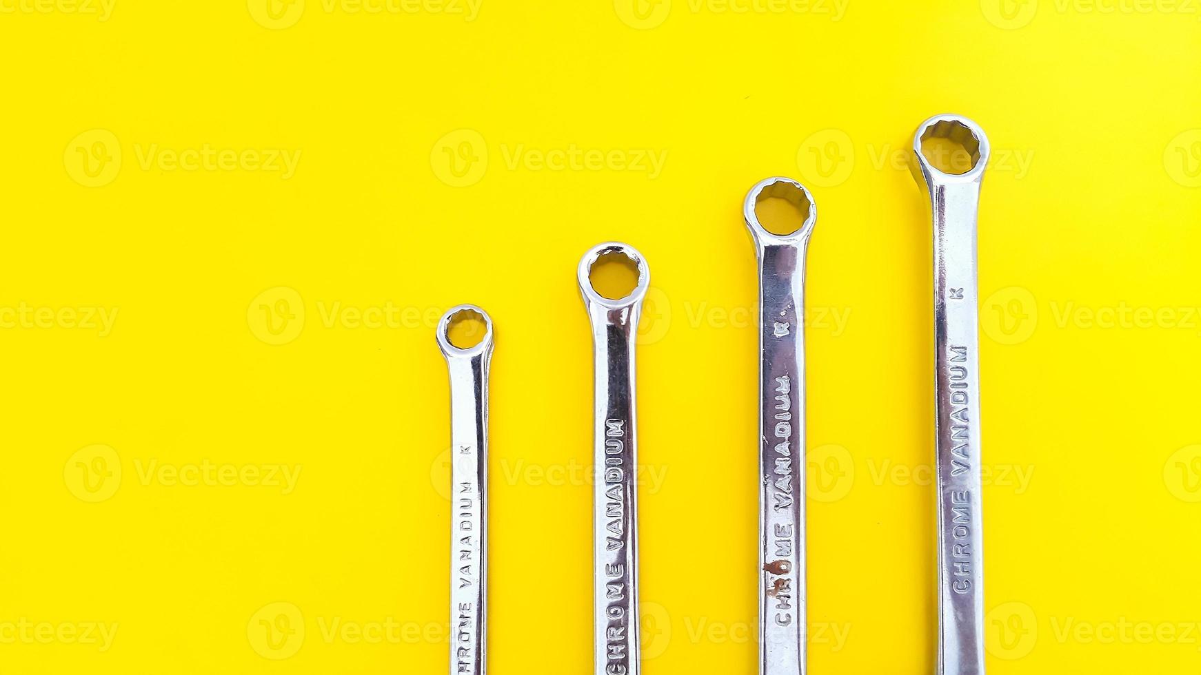 Various sizes of wrench or spanner isolated on yellow background. Mechanical Tool. photo