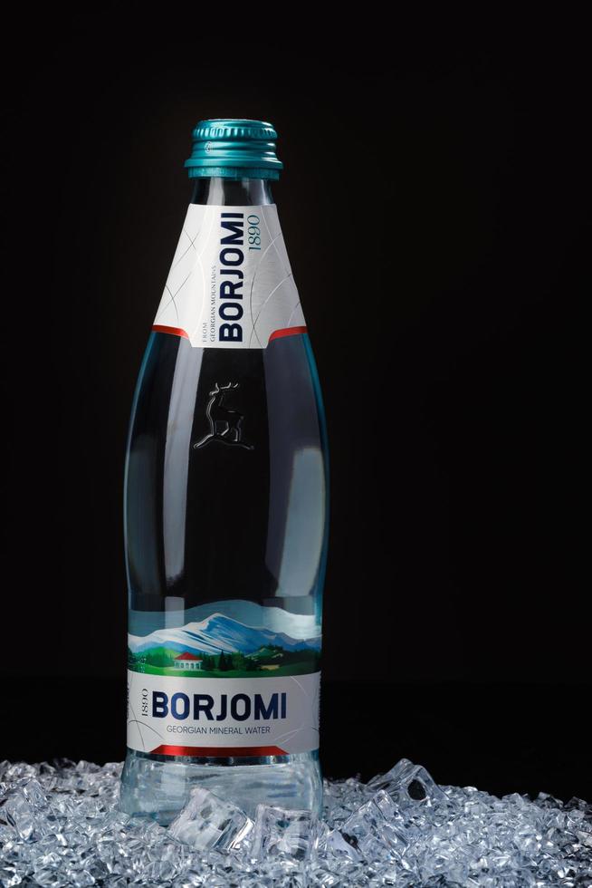 krasnoyarsk, rusia - 21 de octubre de 2022 botella de agua mineral borjomi sobre hielo. foto