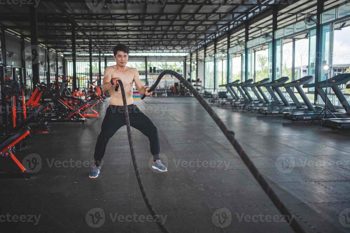 sportsman  doing alternating rope waves in cross training workout. photo