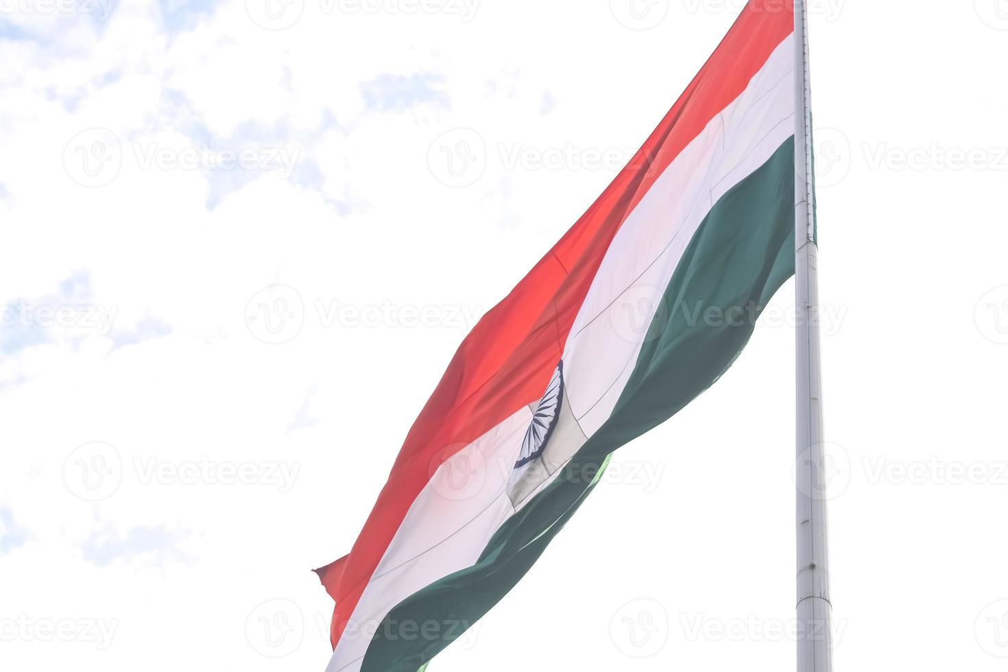 India flag flying high at Connaught Place with pride in blue sky, India flag fluttering, Indian Flag on Independence Day and Republic Day of India, tilt up shot, Waving Indian flag, Har Ghar Tiranga photo